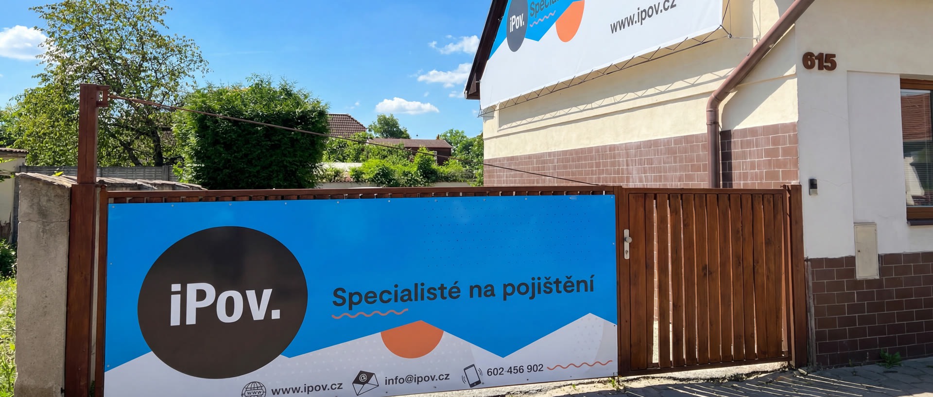 Exteriér kanceláře iPov v Praze Horních Počernicích s firemní plachtou